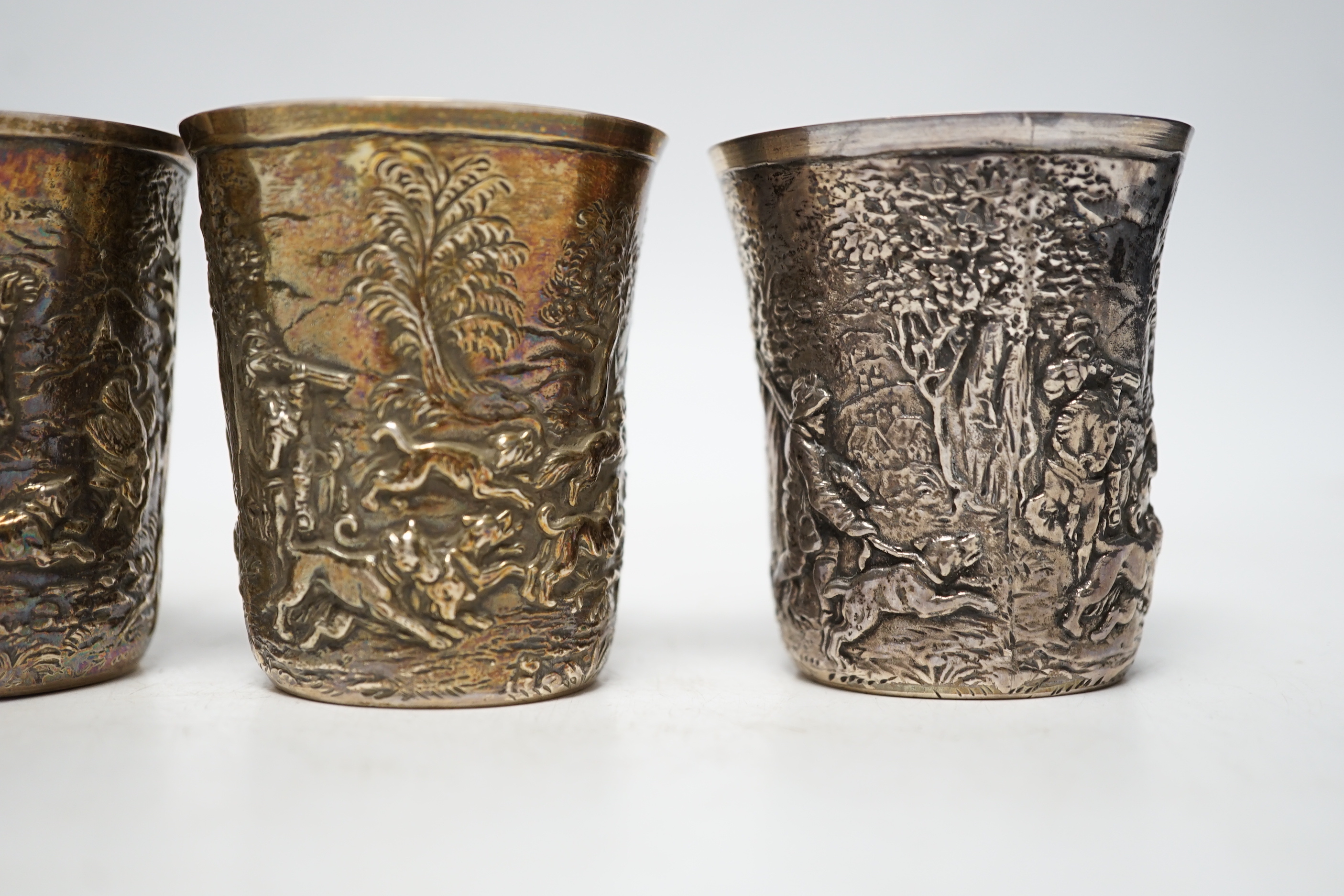 A set of five late 19th century German embossed 925 beakers, decorated with continuous hunting scenes, by Neresheimer Ludwig & Co, 67mm, 16.7oz